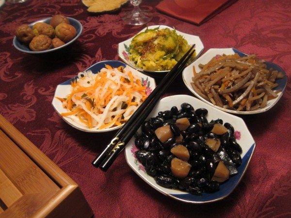 More side dishes. "Red and White" carrot and daikon (salted and seasoned with sweet rice vinegar), abalone salad with tobiko, burdock root and carrot kimpira, and black beans.