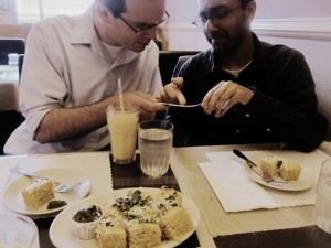 Hull and Surendranath examine the inscription on a spoon at Bombay Cuisine.